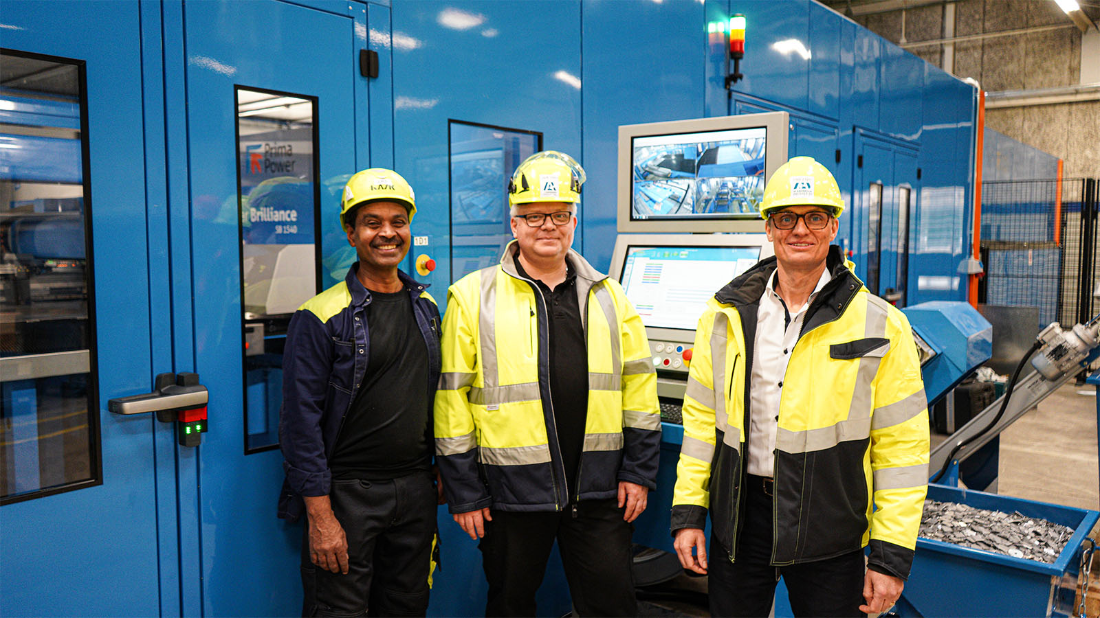 Drei Mitarbeiter stehen vor dem neuen Stanzanlage von Ib Andresen Industri.
